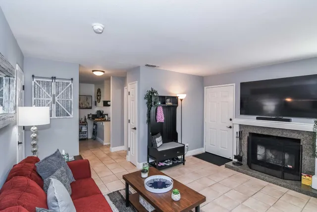 a living room with furniture a flat screen tv and a fireplace