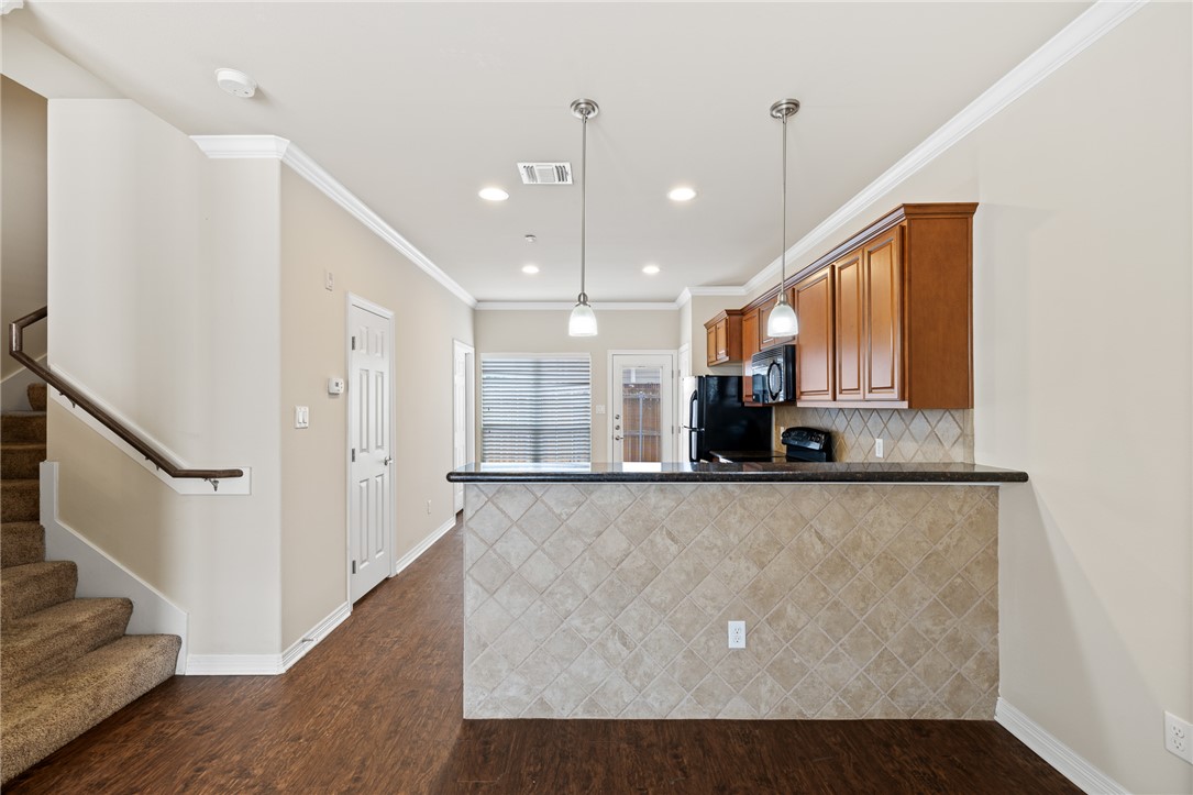 1198 Jones-Butler Road, Unit 1003 College Station, TX 77840 - Photo 3 of 42 a view of a kitchen with stainless steel appliances granite countertop a refrigerator a sink and a stove with wooden floor