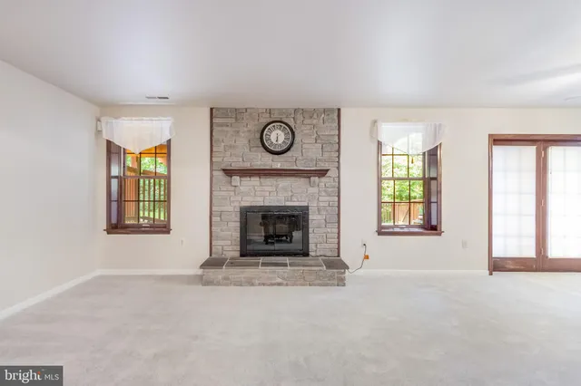 a view of an empty room with a fireplace and a window