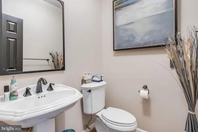 a bathroom with a sink mirror and toilet