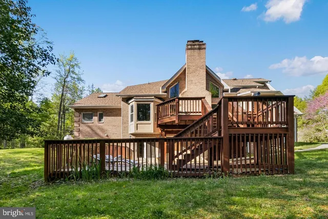 a view of a house with a yard and deck