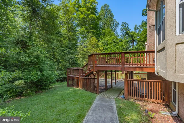 a view of a deck with a table and chairs under an umbrella with wooden fence