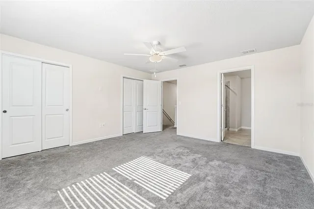 a view of an empty room with a ceiling fan