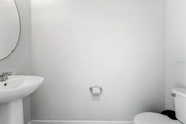 a bathroom with a sink mirror and toilet