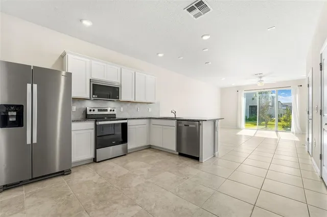a kitchen with stainless steel appliances a refrigerator sink and microwave