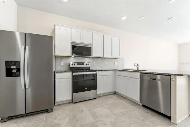 a kitchen with stainless steel appliances a refrigerator stove and microwave