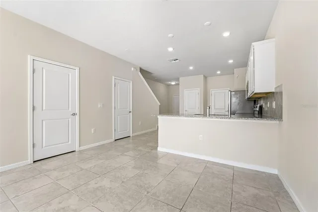 a view of kitchen with stainless steel appliances refrigerator stove microwave and cabinets