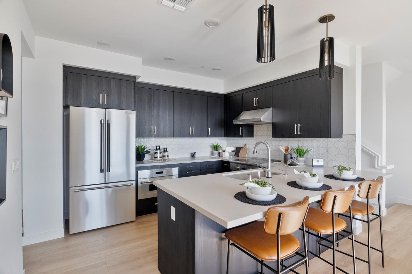 a kitchen with a refrigerator a stove a sink and chairs