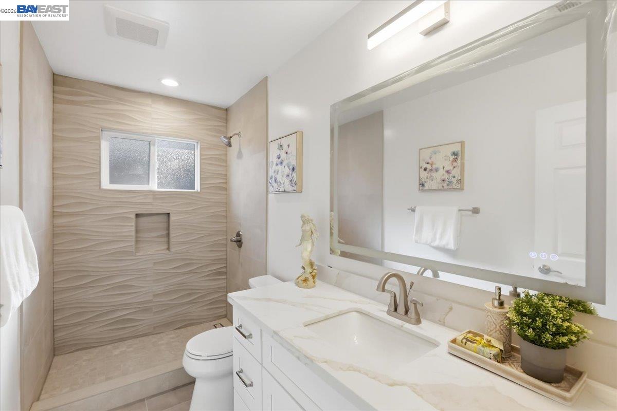 4519 Edwards Lane Castro Valley, CA 94546 - Photo 19 of 46 a bathroom with a granite countertop toilet a sink and a mirror