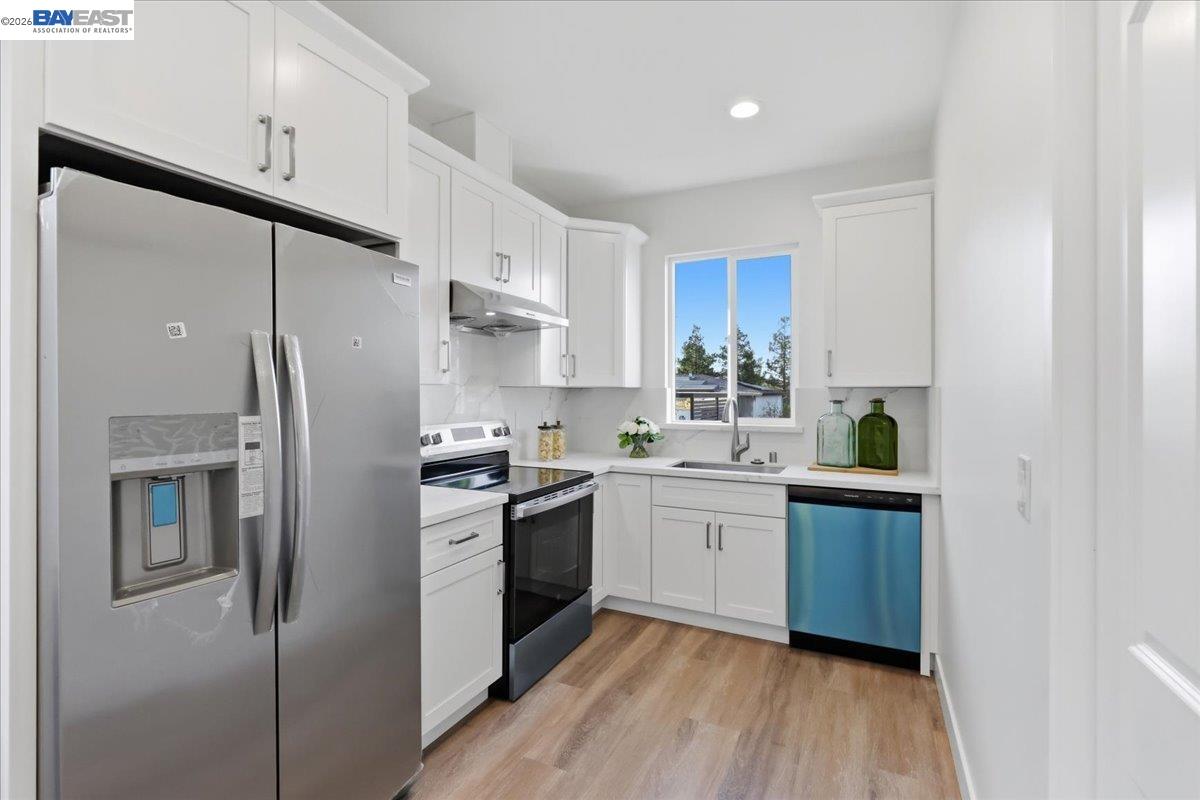 4519 Edwards Lane Castro Valley, CA 94546 - Photo 33 of 46 a kitchen with stainless steel appliances granite countertop a refrigerator a sink dishwasher a stove with white cabinets and wooden floor