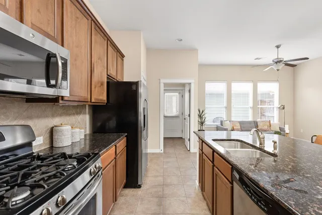 a kitchen with stainless steel appliances granite countertop a sink stove and refrigerator