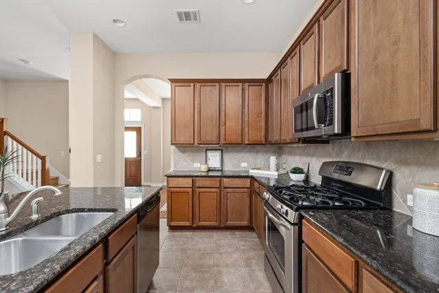 a kitchen with granite countertop a sink stove and cabinets