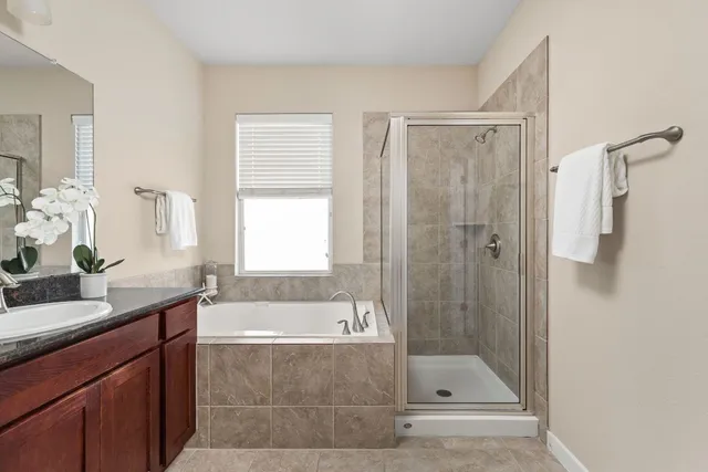 a bathroom with a bath tub a sink and shower
