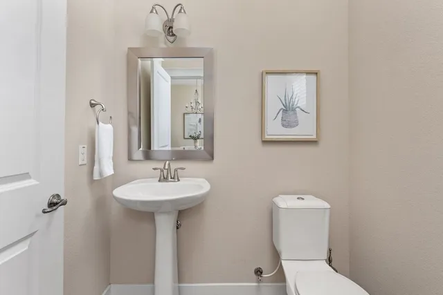 a bathroom with a sink toilet and a mirror