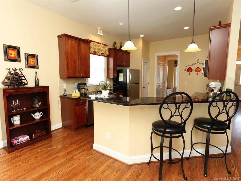 742 Revival Row Fort Mill, SC 29708 - Photo 9 of 24 a kitchen with stainless steel appliances granite countertop a refrigerator a stove a sink dishwasher and a microwave with wooden floor