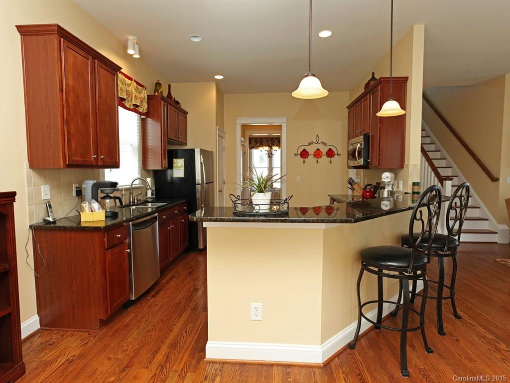 742 Revival Row Fort Mill, SC 29708 - Photo 10 of 24 a kitchen with stainless steel appliances granite countertop wooden floors sink and cabinets