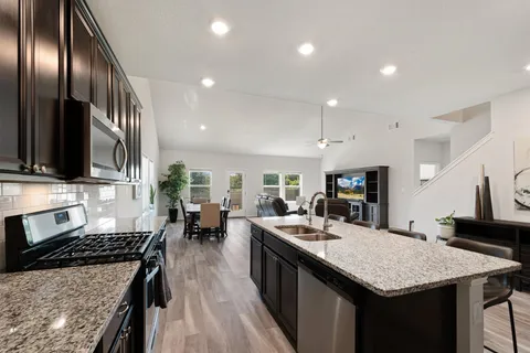 a kitchen with stainless steel appliances granite countertop a sink stove and refrigerator