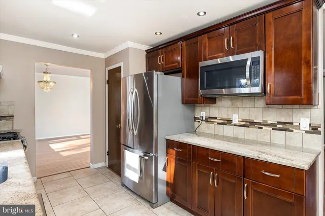 a kitchen with stainless steel appliances granite countertop a refrigerator microwave and sink