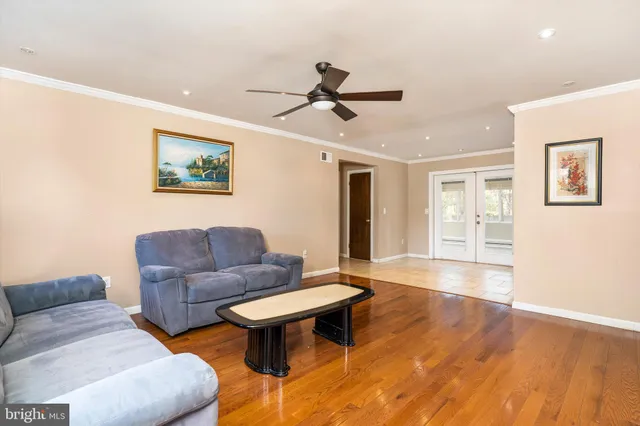 a living room with couches a coffee table and dresser with wooden floor