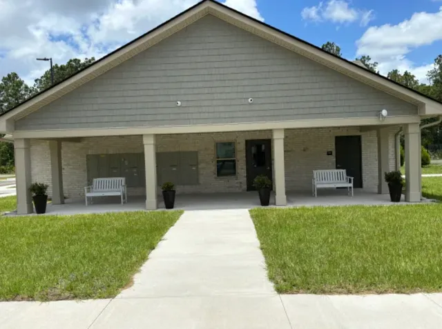 a front view of a house with a garden and plants