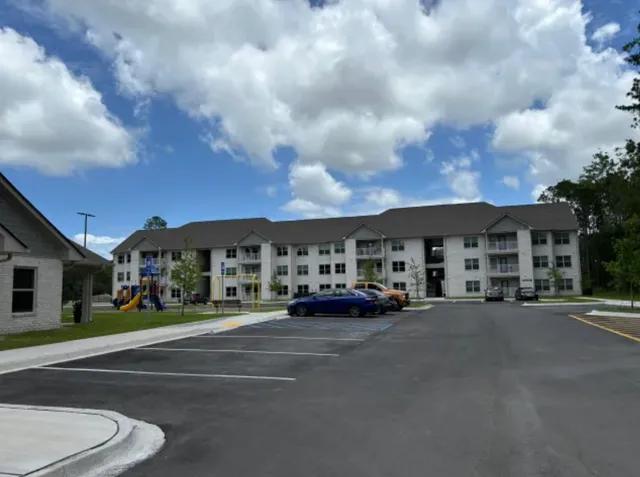 a front view of a house with a garden and trees