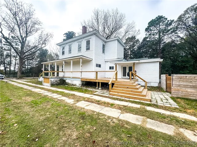 a view of a house with a yard covered in snow