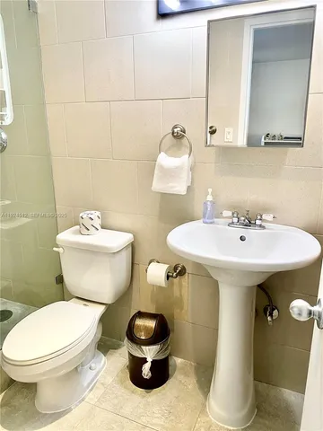 a bathroom with a sink toilet and a mirror