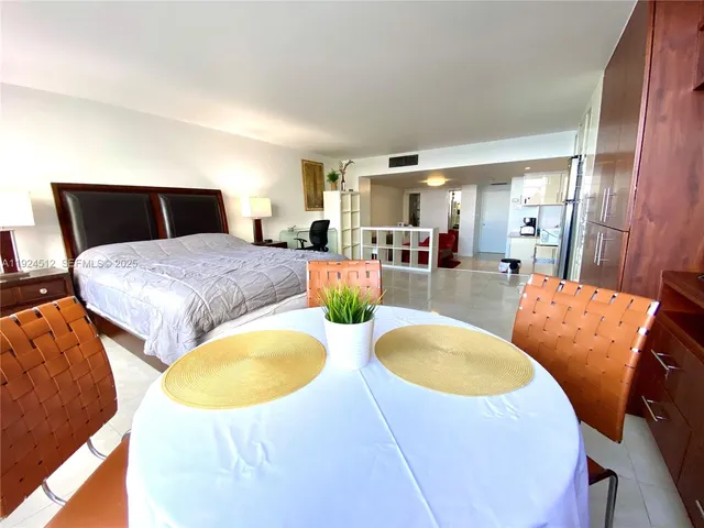 a living room with stainless steel appliances furniture a chandelier and a mirror