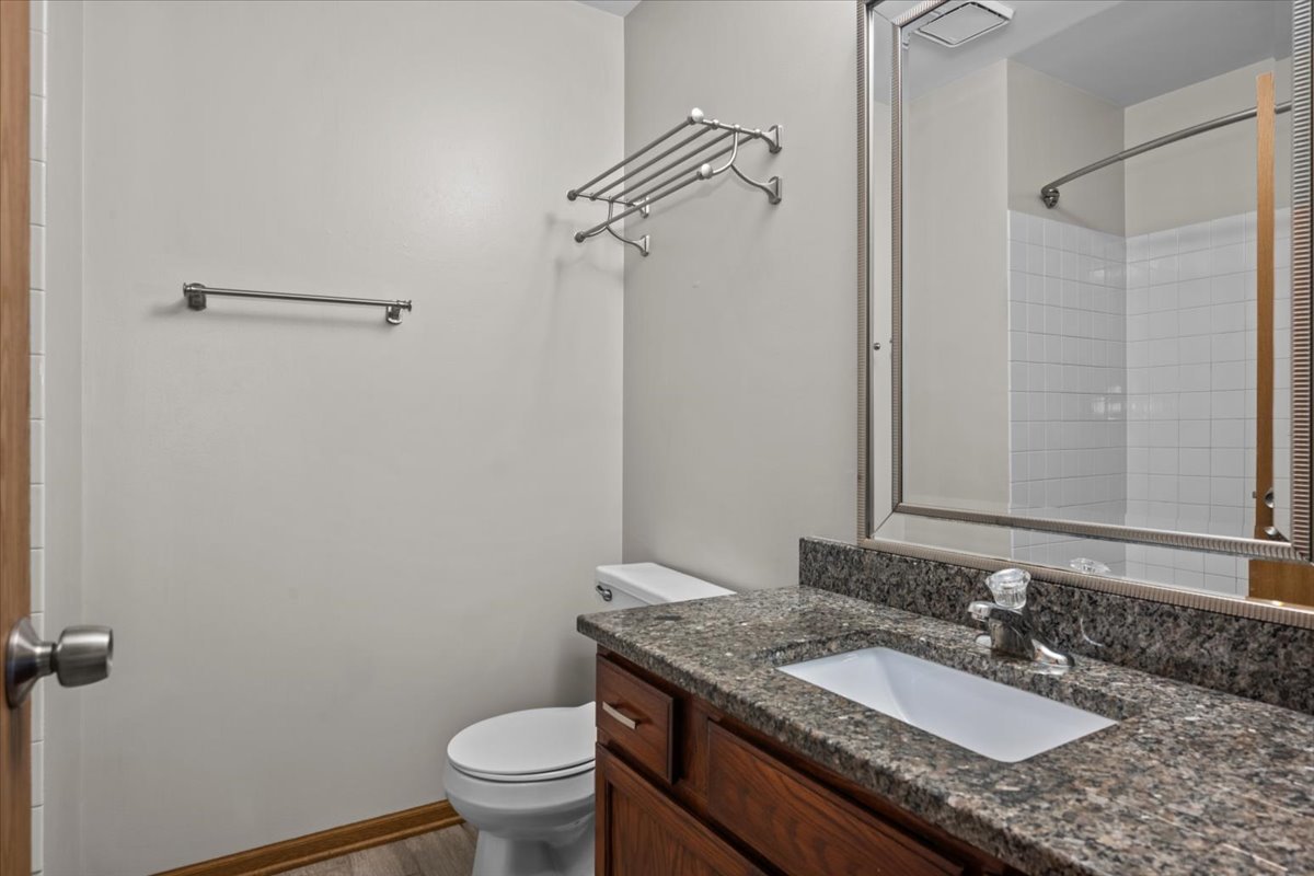 1215 Koster Court Geneva, IL 60134 - Photo 16 of 22 a bathroom with a granite countertop sink a toilet and a mirror