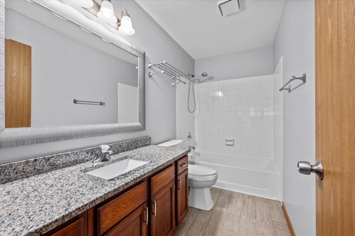 1215 Koster Court Geneva, IL 60134 - Photo 18 of 22 a bathroom with a granite countertop sink a toilet and shower