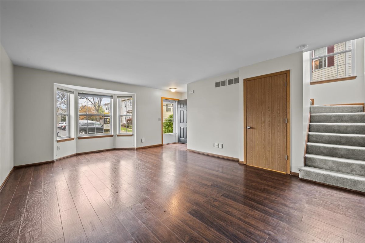 1215 Koster Court Geneva, IL 60134 - Photo 6 of 22 a view of an empty room with wooden floor and a window