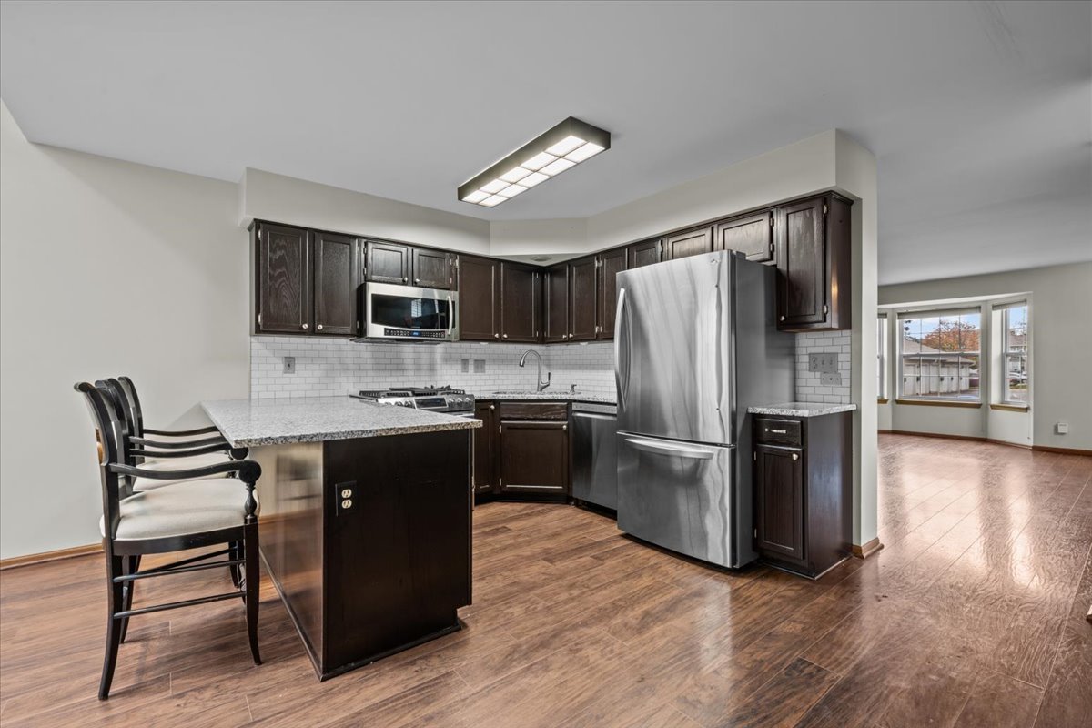 1215 Koster Court Geneva, IL 60134 - Photo 10 of 22 a kitchen with refrigerator cabinets and wooden floor