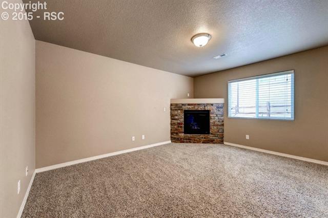 944 Diamond Rim Drive Colorado Springs, CO 80921 - Photo 13 of 28 Spacious family room made cozy with corner fireplace and built in shelf for your entertainment center or decor.