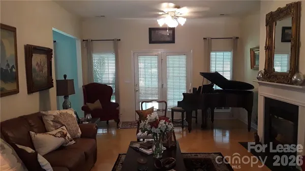 a living room with furniture a chandelier and a flat screen tv