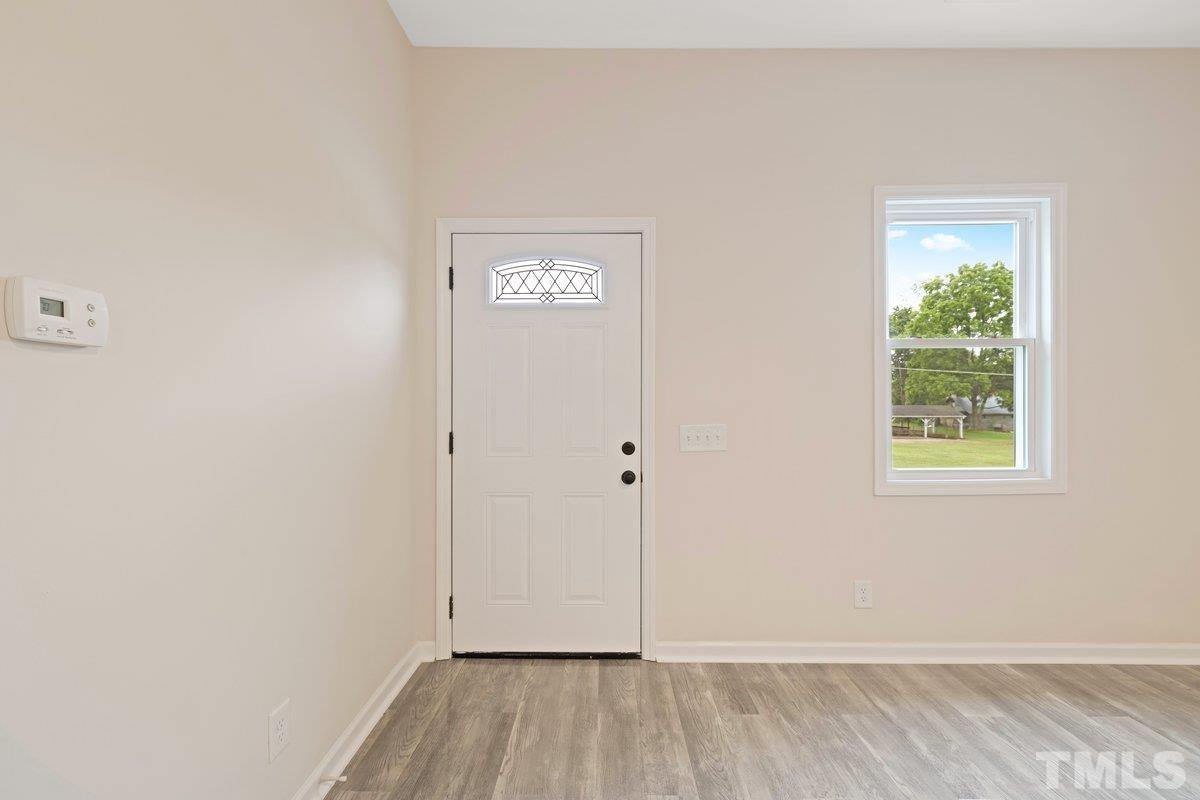 154 Summit Street Roxboro, NC 27573 - Photo 11 of 19 a view of an empty room with wooden floor and a window