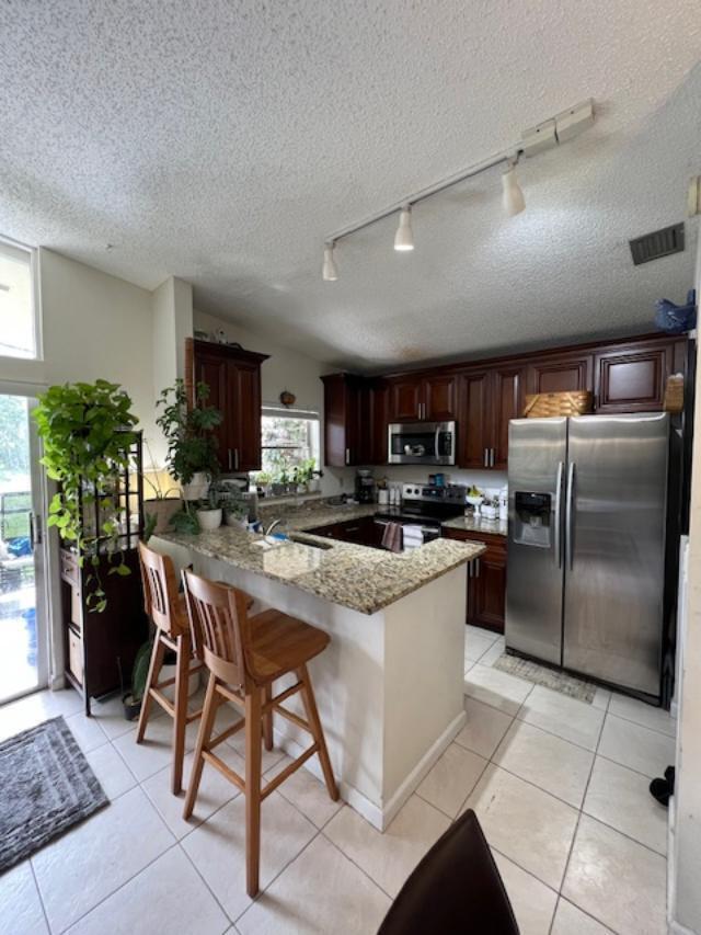 11750 Timbers Way Boca Raton, FL 33428 - Photo 4 of 25 a kitchen with kitchen island granite countertop stainless steel appliances a sink a counter top space cabinets and a window