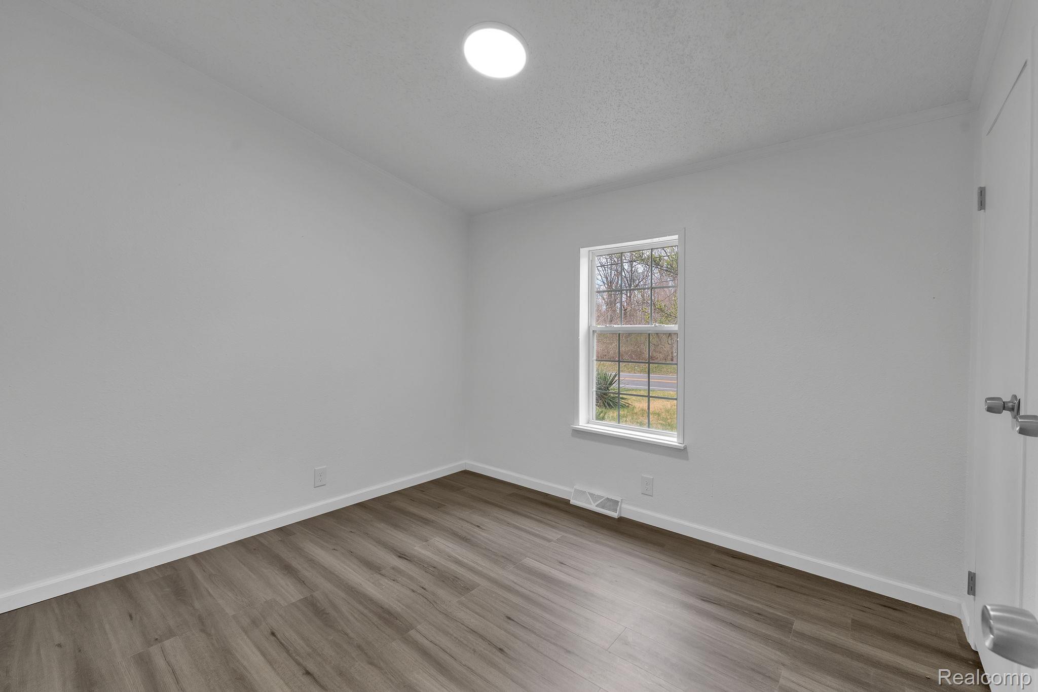 36085 Wick Road Romulus, MI 48174 - Photo 36 of 43 Spare room featuring light wood-type flooring and a textured ceiling