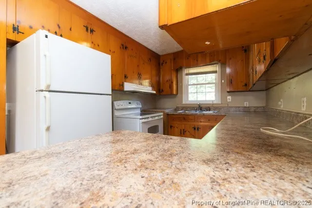 a kitchen with stainless steel appliances a refrigerator sink and cabinets