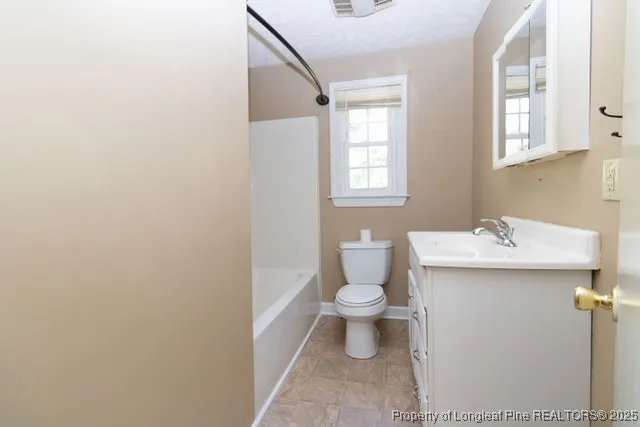 a bathroom with a sink toilet and window