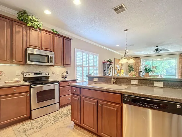 a dining room with furniture a chandelier and kitchen view