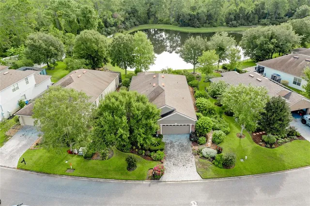 an aerial view of a house with a yard and lake