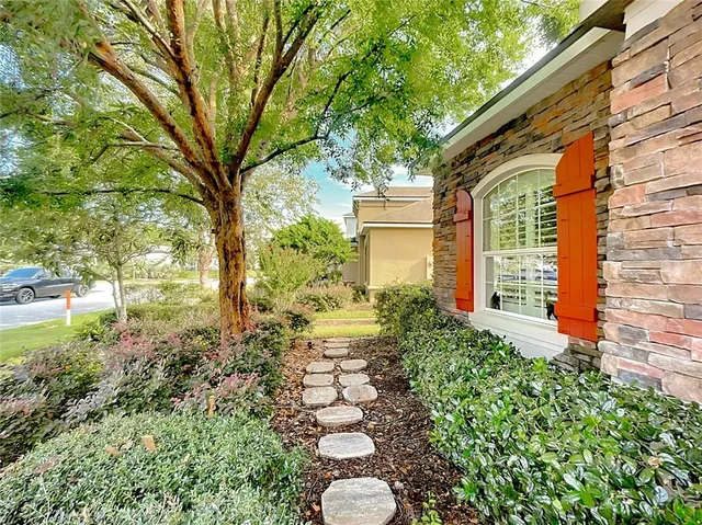 a hallway with a potted plant on a table and a chair