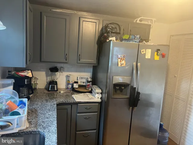 a kitchen with stainless steel appliances granite countertop a refrigerator and a stove