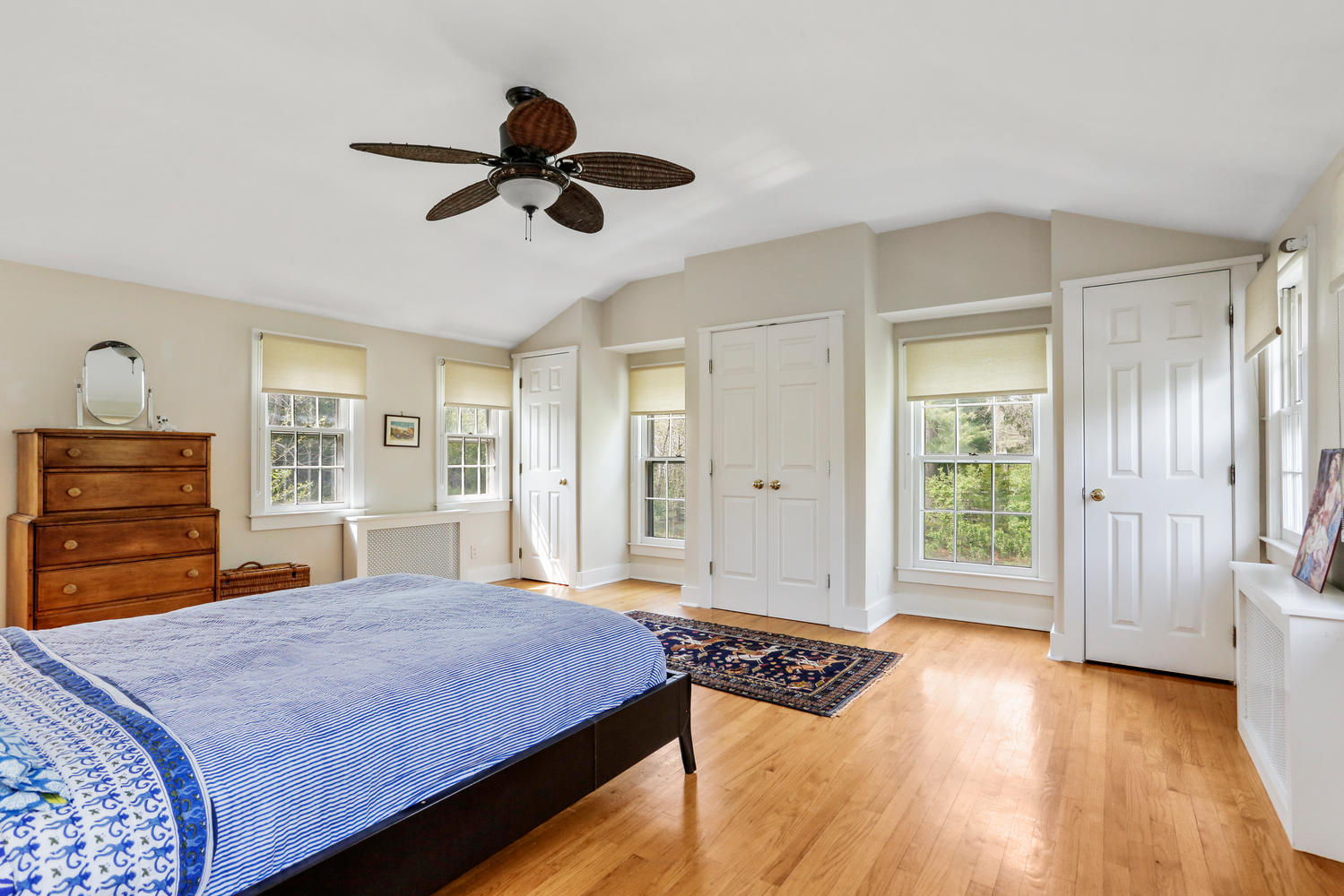 31 Jelliff Mill Road New Canaan, CT 06840 - Photo 22 of 51 a spacious bedroom with a bed a dresser and a chandelier