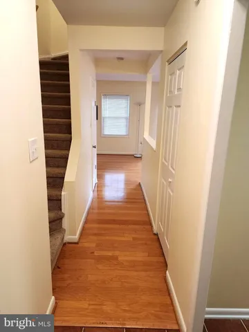 a view of a hallway with wooden floor and staircase