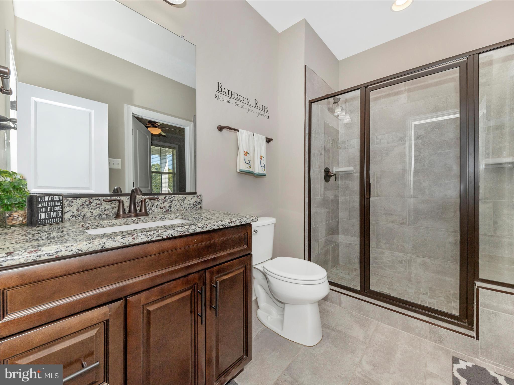 14671 Sugarland Road Poolesville, MD 20837 - Photo 22 of 62 a bathroom with a granite countertop sink toilet and shower