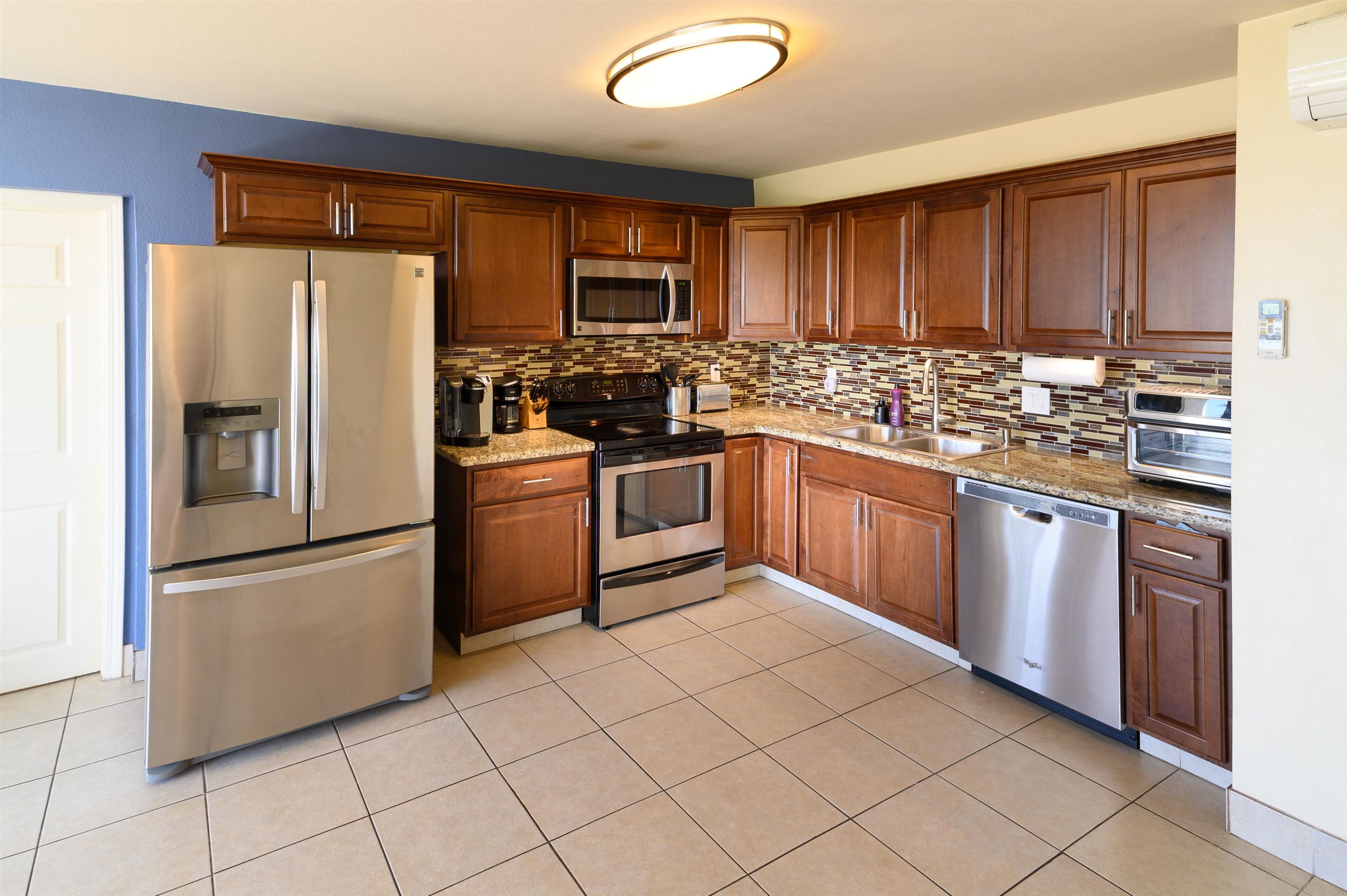 1993 South Kihei Road, Unit 201 Kihei, HI 96753 - Photo 1 of 11 a kitchen with stainless steel appliances granite countertop a stove top oven a refrigerator and a sink