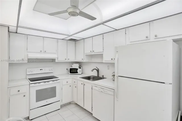 a kitchen with stainless steel appliances white cabinets and white appliances