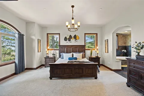 a living room with couch chandelier and a window