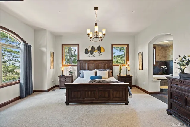 a living room with couch chandelier and a window